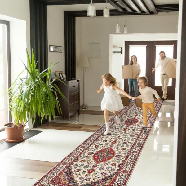 Kinderen lopen over een lange oosterse loper in crème en rood in de entree.