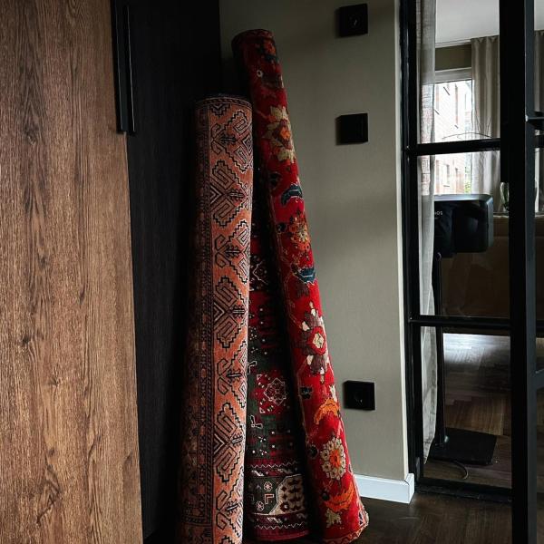 Rolled oriental rugs in shades of red in the hallway