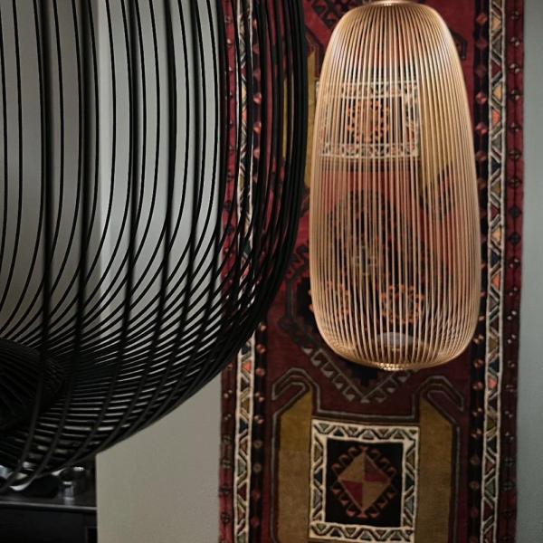 Oriental carpet with geometric pattern as a wall hanging behind designer pendant lights.