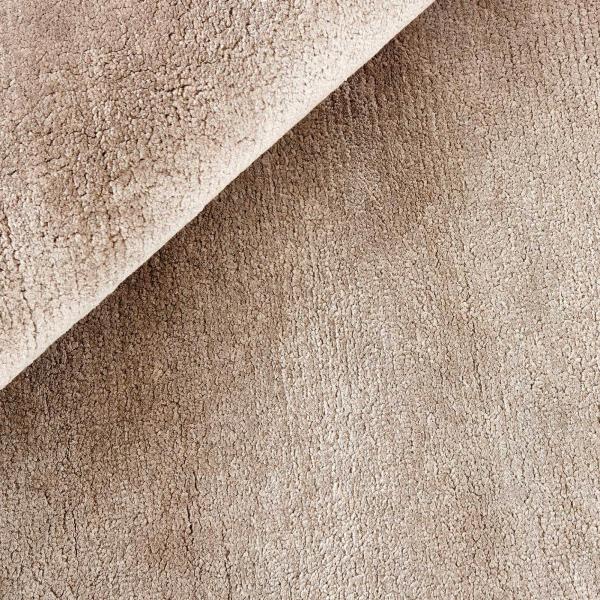 Beige high-pile carpet with a soft, dense surface and subtle texture.