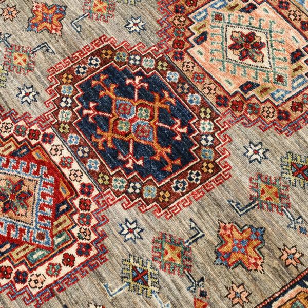 Gros plan d'un tapis kazakh avec des symboles géométriques