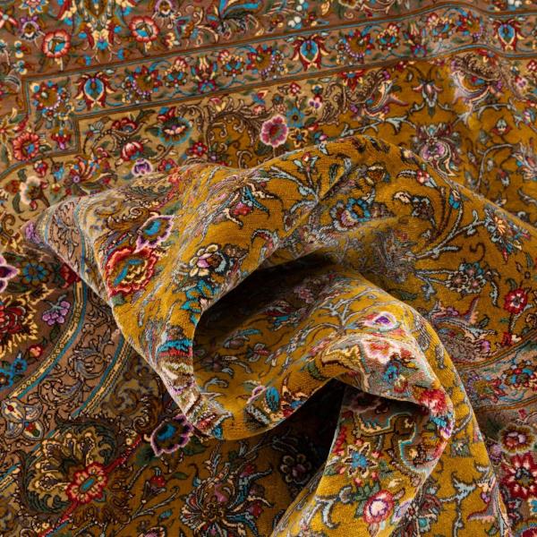 Close-up de um tapete persa de seda feito à mão com finos padrões florais.