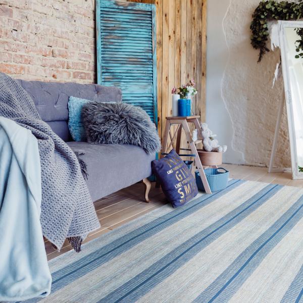 Tapete kilim moderno com padrão de listras em azul na sala de estar.