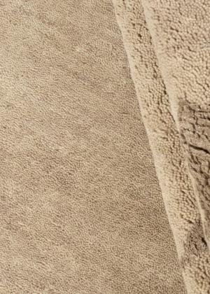 Alfombra de pelo alto en color beige.