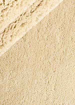 Alfombra acogedora con una estructura densa en un claro crema.