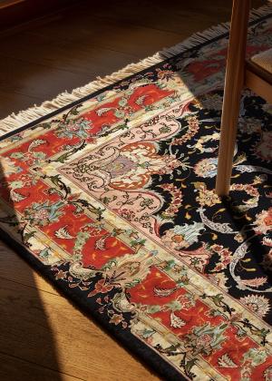 Tebriz perzsaszőnyeg az étkezőasztal alatt