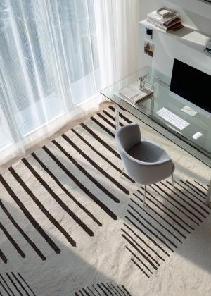 Modern rug with geometric stripe pattern in a bright study.
