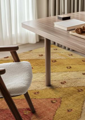 Modern Gabbeh rug in warm natural colours under a wooden table