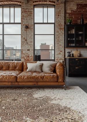 Modern rug with a striped pattern in an industrial living room with a leather sofa.