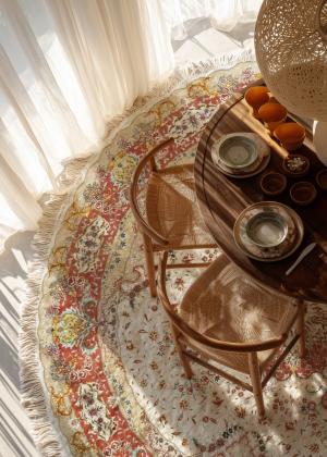 Tappeto rotondo Tabriz con ornamenti floreali sotto il tavolo